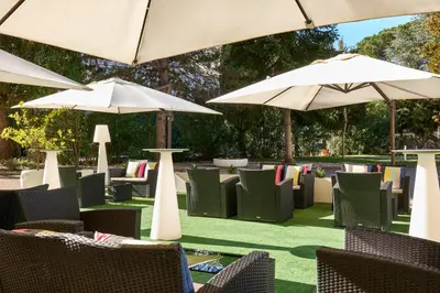 a group of chairs and umbrellas on a lawn at Occidental Aurelia in Rome