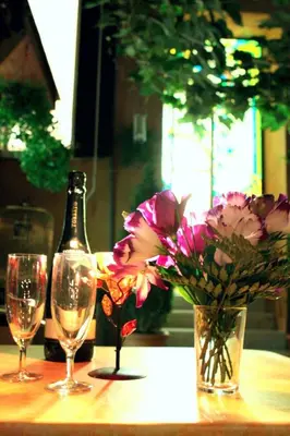 a bottle of wine and two glasses and flowers on a table at Soggiorno Angelus in Rome