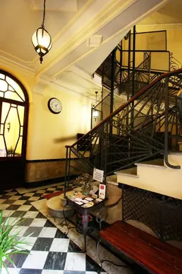 a lobby with a staircase and a table and a clock at Soggiorno Angelus in Rome