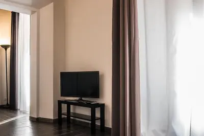 a television on a table in a room with curtains at Pantheon116 in Rome