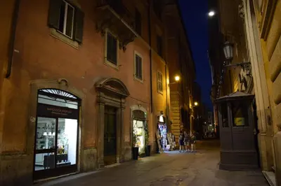 a city street at night with people walking down the street at Pantheon116 in Rome