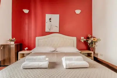 a bedroom with a large bed with red walls at Ariana Luxury Guest House in Rome