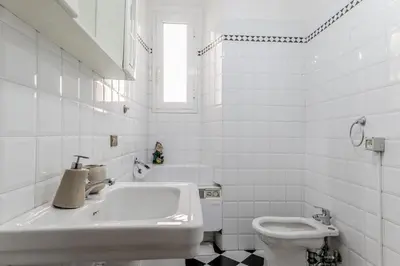 a white bathroom with a sink and a toilet at Ariana Luxury Guest House in Rome