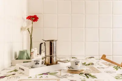 a table with two cups and a vase with a flower at Ariana Luxury Guest House in Rome