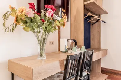 a vase of flowers sitting on a table with two chairs at Ariana Luxury Guest House in Rome