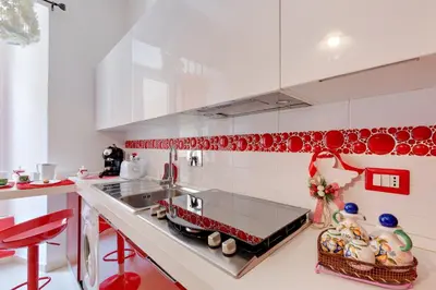 a kitchen with red and white tile walls at New In! Sophie at Colosseum in Rome