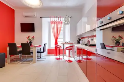 a kitchen with red walls and a table with red stools at New In! Sophie at Colosseum in Rome