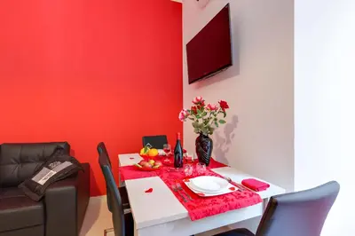a dining room with a table with a red wall at New In! Sophie at Colosseum in Rome