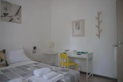 a bedroom with a bed and a desk with a chair at Domus Amica in Rome