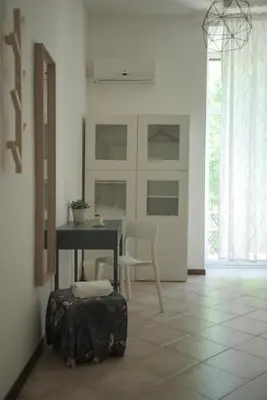 a room with a table and a chair and a suitcase at Domus Amica in Rome