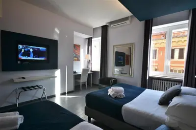 a hotel room with two beds and a flat screen tv at B&B Home 77 in Rome