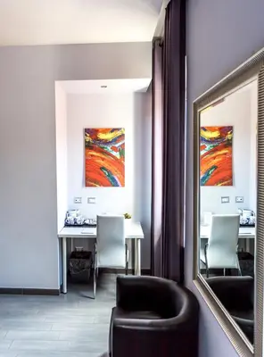 a room with two tables and a chair and a mirror at B&B Home 77 in Rome