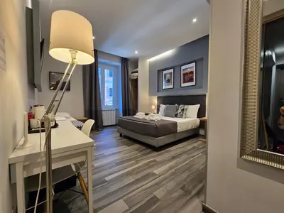 a living room with a bed and a desk with a lamp at B&B Home 77 in Rome