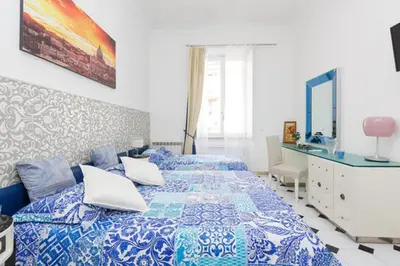 a bedroom with two beds with blue and white sheets at Vatican Catone Apartments in Rome