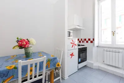 a kitchen with a table with a vase of flowers on it at Vatican Catone Apartments in Rome