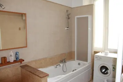 a bathroom with a tub and a washing machine at A Casa Di Magda (Al centro di Roma) in Rome