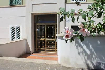 a door to a building with pink flowers in front at A Casa Di Magda (Al centro di Roma) in Rome