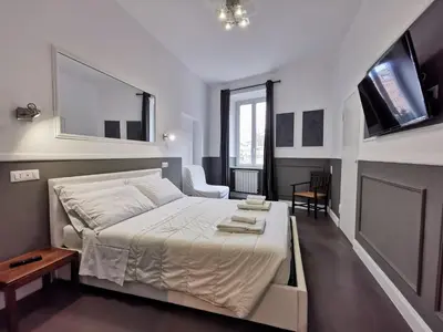 a bedroom with a large white bed and a large window at CoolHouse at Colosseo in Rome