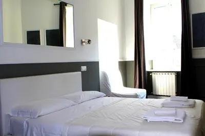 a bedroom with a white bed with towels on it at CoolHouse at Colosseo in Rome