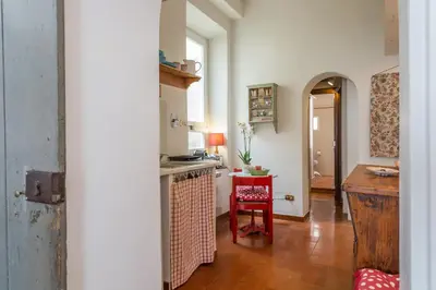 a kitchen with a counter and a table with a chair at Sora Menica in Rome