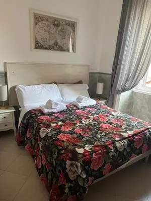 a bedroom with a bed with a floral blanket at Guest House Relais Indipendenza in Rome