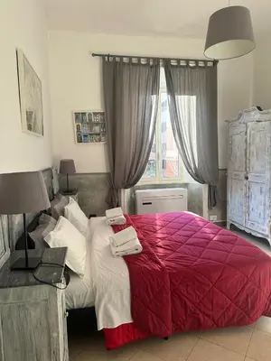 a bedroom with a large bed with a red blanket at Guest House Relais Indipendenza in Rome
