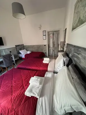 a bedroom with two beds with red and white sheets at Guest House Relais Indipendenza in Rome