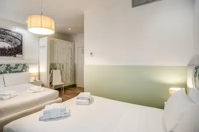 two beds in a room with white walls at A Peace Of Rome B&B in Rome