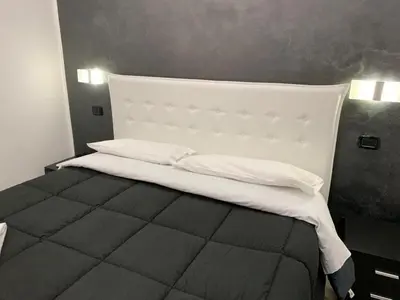 a bedroom with a large bed with a white headboard at Italy Guest House in Rome