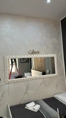 a mirror on a wall above a bed at Italy Guest House in Rome