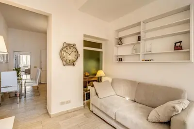 a living room with a couch and a clock on the wall at GuestHouse o Affittacamere Casa Fienaroli 2 in Rome