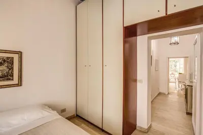 a bedroom with white walls and a bed and a hallway at GuestHouse o Affittacamere Casa Fienaroli 2 in Rome