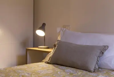 a bed with a pillow and a lamp on a table at Cozy apartment in via degli Spagnoli - FromHometoRome in Rome