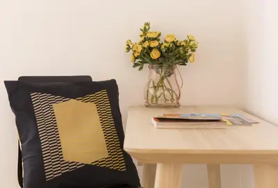a table with a vase of yellow flowers on a table at Cozy apartment in via degli Spagnoli - FromHometoRome in Rome