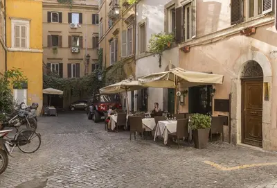 an outdoor restaurant with tables and umbrellas on a street at Cozy apartment in via degli Spagnoli - FromHometoRome in Rome