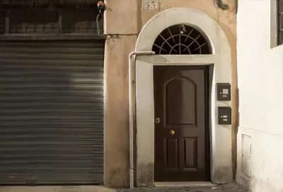 a black door in front of a garage at Cozy apartment in via degli Spagnoli - FromHometoRome in Rome
