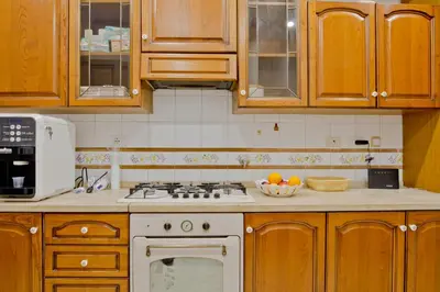 a kitchen with wooden cabinets and a stove top oven at Oscar 2 in Rome