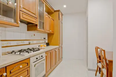 a kitchen with wooden cabinets and a stove top oven at Oscar 2 in Rome