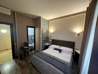 a bedroom with a large bed and a bathroom at Candia Rooms in Rome