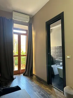 a bathroom with a mirror and a sink and a tub at Candia Rooms in Rome