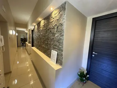 a hallway with a stone wall in a house at Candia Rooms in Rome