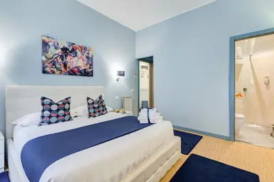 a bedroom with a large bed with blue walls at Easy Budget Colosseo in Rome