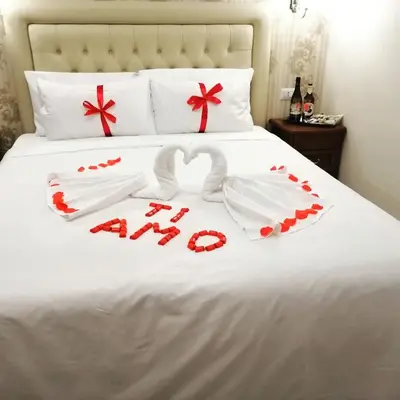 a bed with two swans and red bows at Suite Dal Conte in Rome