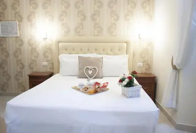 a bedroom with a white bed with a heart on it at Suite Dal Conte in Rome