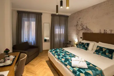 a hotel room with a large bed and a couch at Navona Essence Hotel in Rome