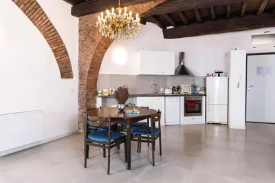 a kitchen with white cabinets and a table and chairs at Trastevere Casa Renella 92 in Rome
