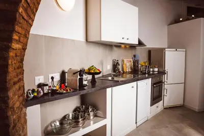 a kitchen with white cabinets and a white refrigerator at Trastevere Casa Renella 92 in Rome