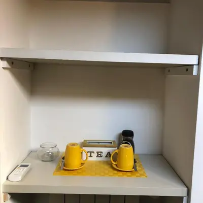 a shelf with two yellow mugs and a scale on it at BB Il Re Alla Reginella Guest House in Rome