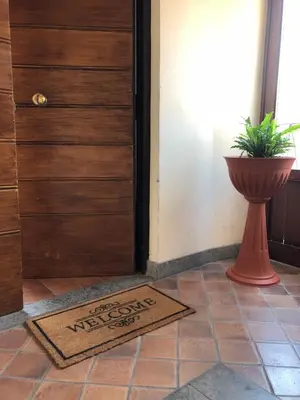 a welcome mat in front of a door with a plant at BB Il Re Alla Reginella Guest House in Rome