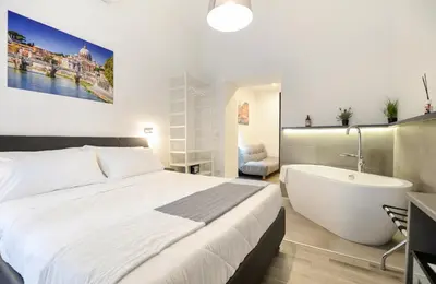 a bedroom with a large bed and a bath tub at Clementi 18 Suites Rome in Rome